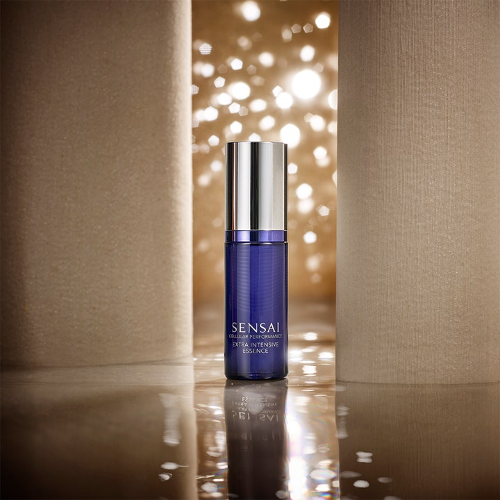 Sensai Cellular Performance Extra Intensive Essence 40 ml gir huden glød i blå flaske med sølvlokk og lysende bakgrunn.