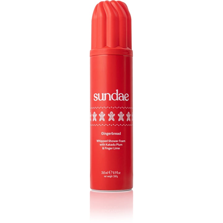 Sundae Gingerbread Whipped Shower Foam 265 ml pleiende dusjskum for kroppspleie i rød flaske med hvite pepperkakemenn.