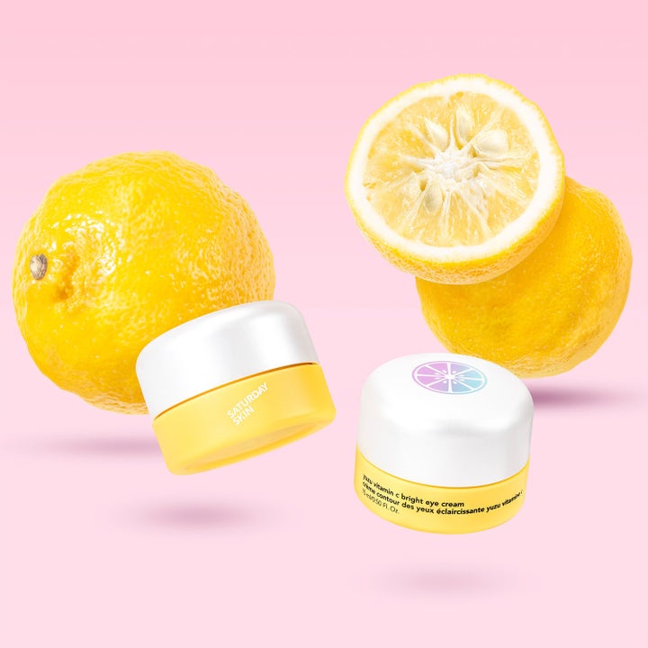 Saturday Skin Yuzu Vitamin C Bright Eye Cream 15 ml øyekrem i gule krukker med yuzu-frukter på rosa bakgrunn