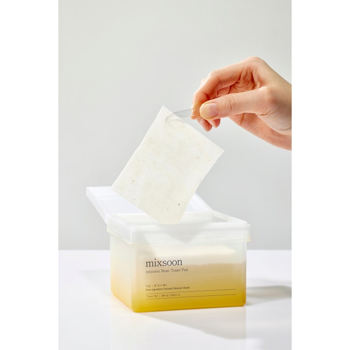 Mixsoon Bean Toner Pad 70 stk fuktighetsgivende pads som løftes ut av en firkantet boks med pinsett.