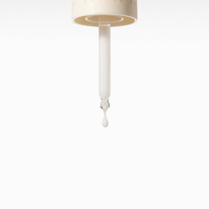 Dr. Ceuracle Vegan Niacin & Rice Ampoule 30 ml serum med en melkeaktig tekstur som drypper fra en pipette.