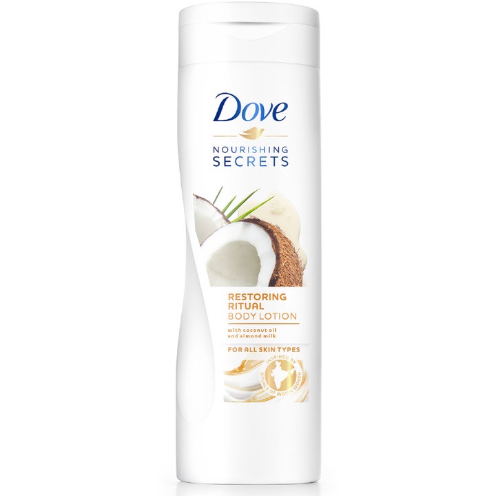 Dove Nourishing Secrets Restoring Ritual Body Lotion pleiende krem i hvit flaske med bilde av kokos og mandelmelk.