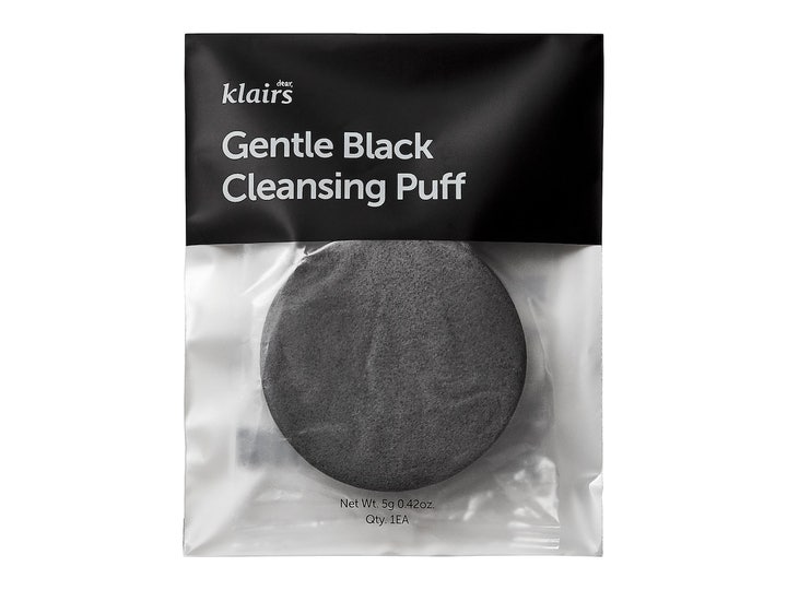 Klairs Gentle Black Cleansing Puff 1 stk gir skånsom eksfoliering med rund mørkegrå svamp i svart og klar plastpose