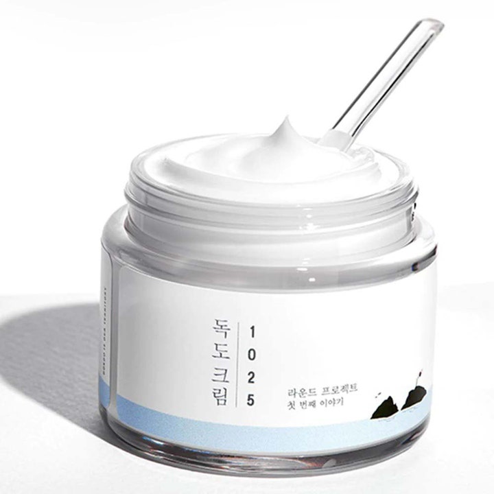 Round Lab 1025 Dokdo Cream 80 ml fuktighetsgivende ansiktskrem viser en fyldig hvit tekstur i åpen krukke med spatel