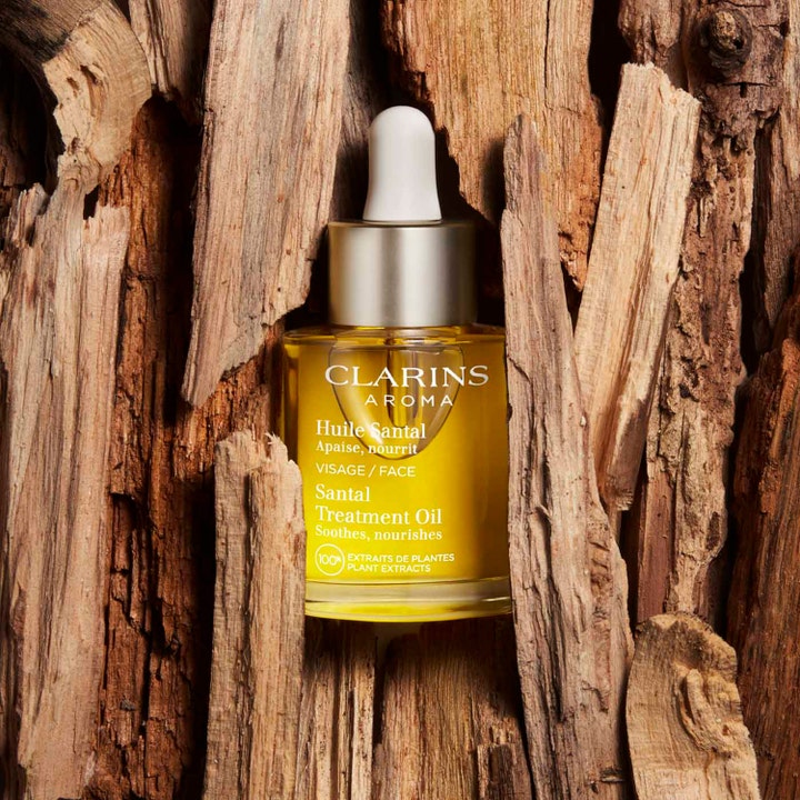Clarins Santal Face Treatment Oil 30 ml beroligende ansiktsolje i glassflaske omgitt av naturlig bark