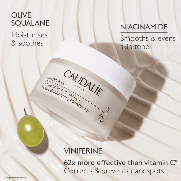 Caudalie Vinoperfect 50 ml dagkrem mot mørke flekker i frostet krukke med niacinamid og viniferine ved siden av en drue.