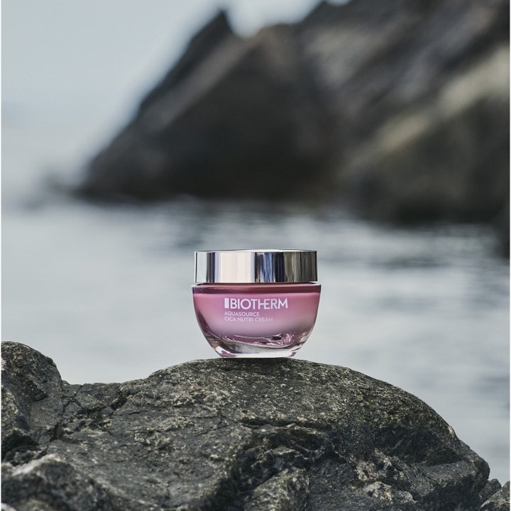 Biotherm Aquasource Cica Nutri 30 ml fuktighetsgivende dagkrem i rosa krukke med sølvlokk plassert på en mørk stein