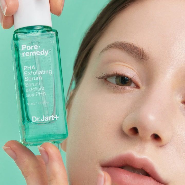 Dr.Jart+ Pore-remedy PHA Exfoliating Serum 30 ml eksfolierende ansiktsserum i grønn glassflaske holdt inntil ansiktet.