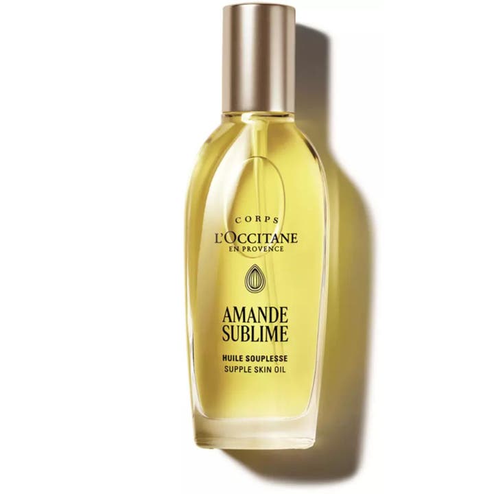 L'Occitane Amande Supple Skin Oil 100 ml nærende mandelolje for myk hud i klar glassflaske med sølvfarget spraypumpe.