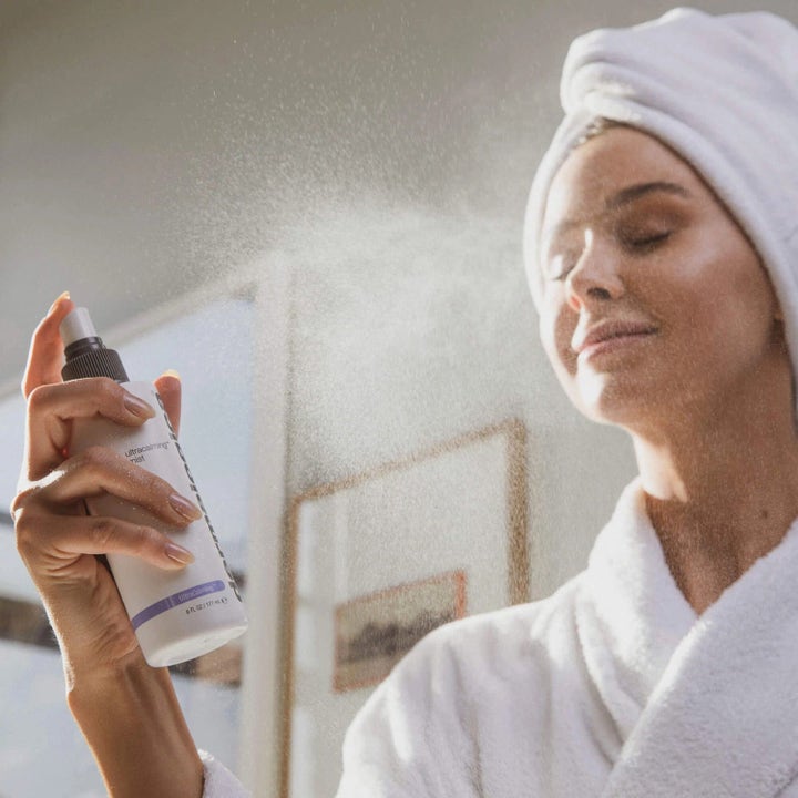 Dermalogica UltraCalming Mist 177 ml beroligende toner sprayes over ansiktet på kvinne i hvit morgenkåpe