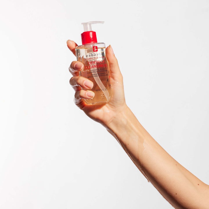 Erborian Centella Cleansing Oil 180 ml beroligende renseolje i en gjennomsiktig pumpeflaske holdt av en hånd