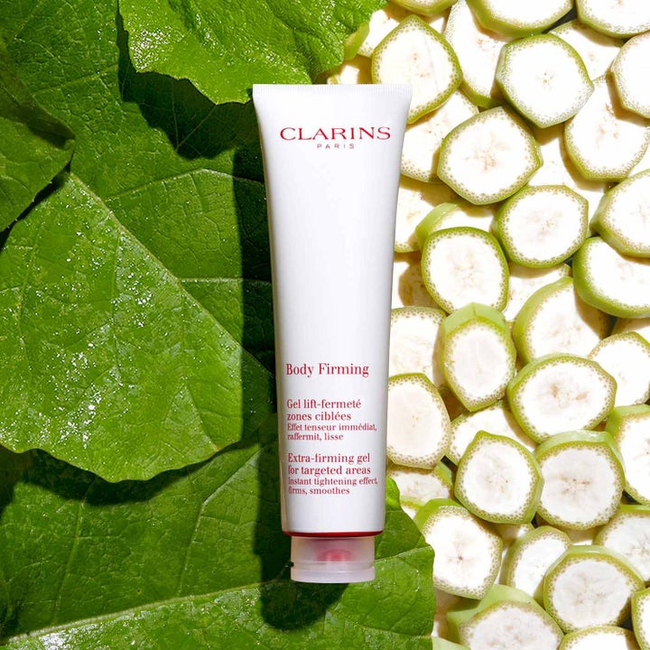 Clarins Body Firming Gel 150 ml på hvit tube som gir fasthet omgitt av grønne blader og bananskiver