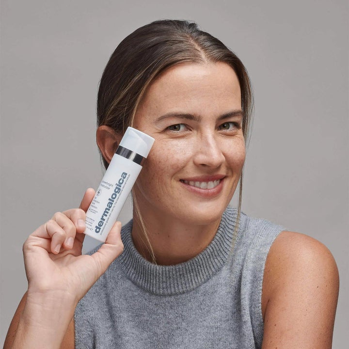 Dermalogica Powerbright Moisturizer SPF50 fuktighetskrem med niacinamid holdes av en smilende kvinne med fregner.