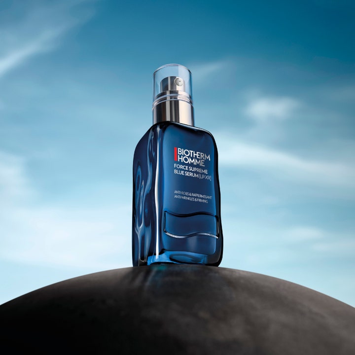 Biotherm Homme Force Supreme Blue Serum 60 ml mot rynker i blå glassflaske mot en blå himmel