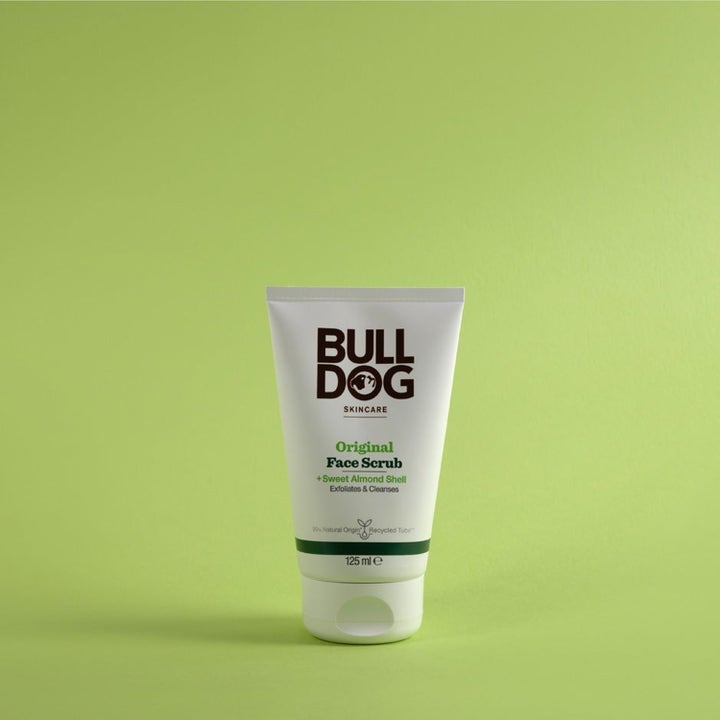 Bulldog Original Face Scrub 125 ml eksfolierende ansiktsskrubb med mandelskall i hvit tube på grønn bakgrunn