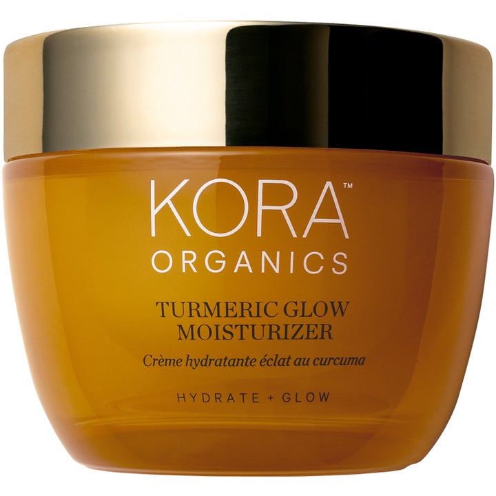 KORA Organics Turmeric Glow Moisturizer fuktighetskrem som gir glød i en ravfarget glasskrukke med gullokk.