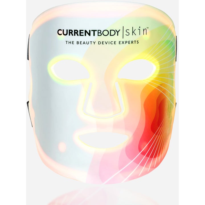 Currentbody Skin LED 4-in-1 Mask hudpleie som gir glød er en hvit ansiktsmaske med et fargerikt bølgemønster.