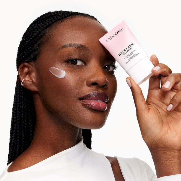 Lancôme Hydra Zen Moisturizing Gel Cream 30 ml beroligende dagkrem i rosa tube holdt av kvinne med krem på kinnet