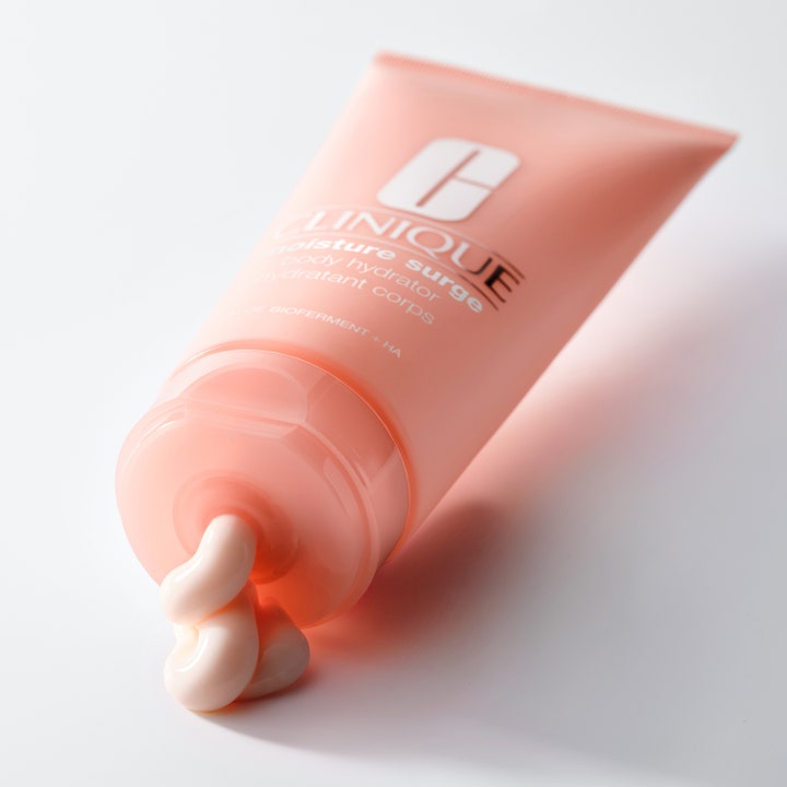Clinique Moisture Surge Body Hydrator 200 ml fuktighetsgivende kroppskrem med lys rosa kremtekstur ut av ferskenfarget tube