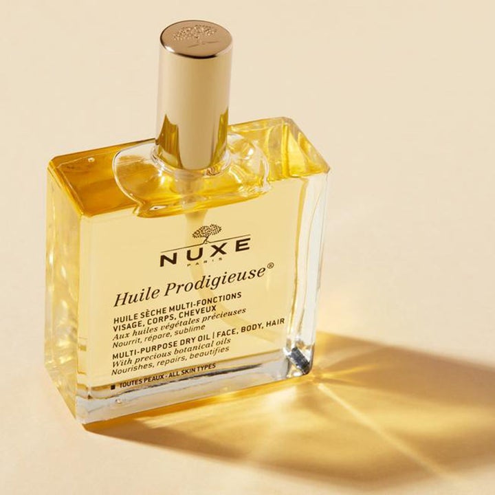 Nuxe Huile Prodigieuse 100 ml fuktighetsgivende tørrolje i en firkantet glassflaske med elegant gullkork.