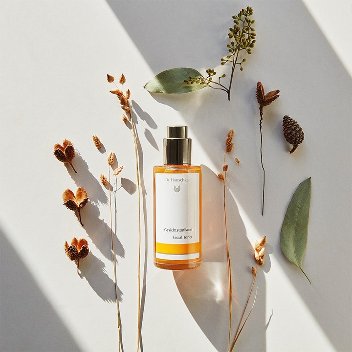 Dr. Hauschka Facial Toner 100 ml styrkende ansiktsvann i glassflaske omgitt av tørkede botaniske blader.