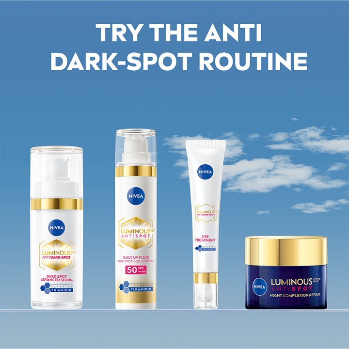 NIVEA Luminous630 Anti Dark-Spot 50 ml nattkrem i en hudpleierutine med serum og dagkrem mot blå himmel.