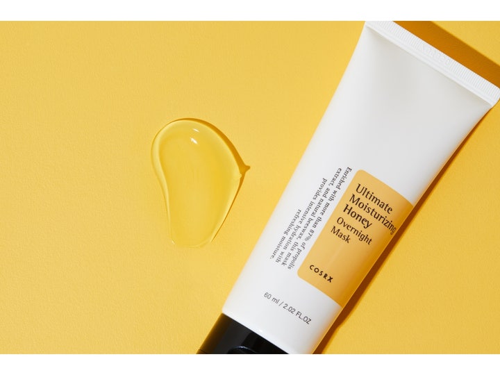 COSRX Ultimate Moisturizing Honey Overnight Mask 60 ml nattmaske i hvit tube med klar geltekstur på gul bakgrunn
