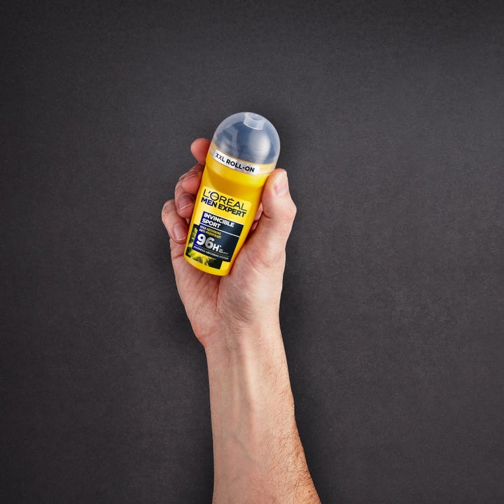 L'Oréal Paris Men Expert Invincible Sport 50 ml 96h anti-perspirant i gul roll-on flaske holdt i en hånd.