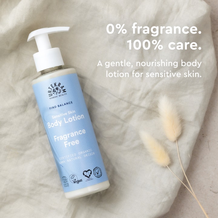 Urtekram Body Lotion Fragrance Free 245 ml i lyseblå pumpeflaske på linstoff med teksten 0% fragrance 100% care.