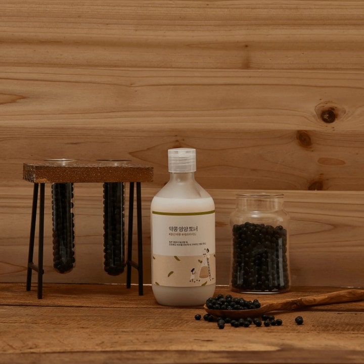 Round Lab Soybean Nourishing Toner 300 ml nærende toner i frostet flaske med svarte soyabønner og rustikk tredekor.