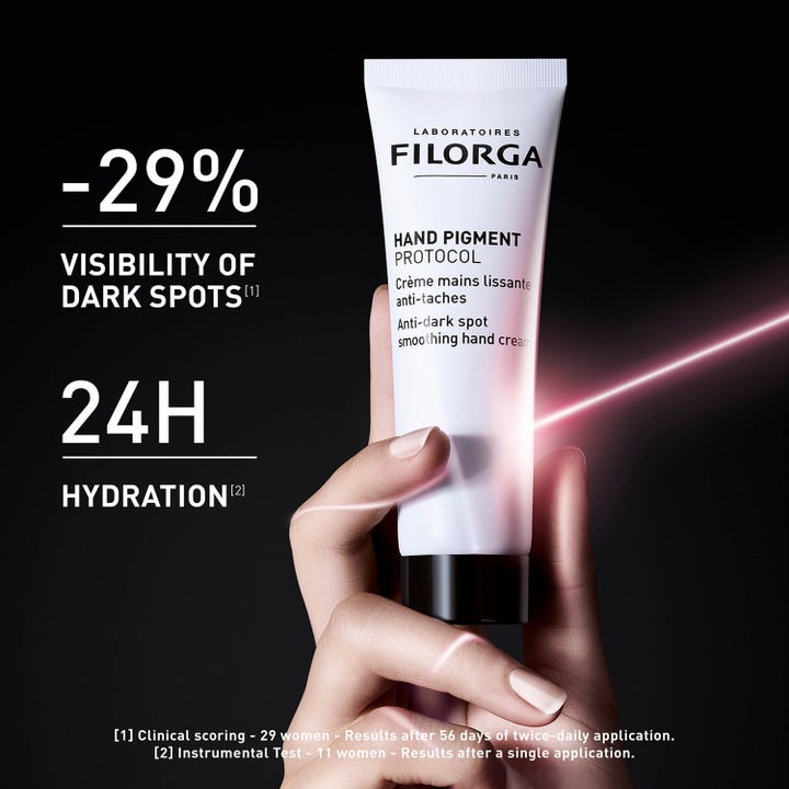 Filorga Hand Pigment Protocol 50 ml handkrem i hvit tube holdt av en hånd som gir fuktighet og demper mørke flekker