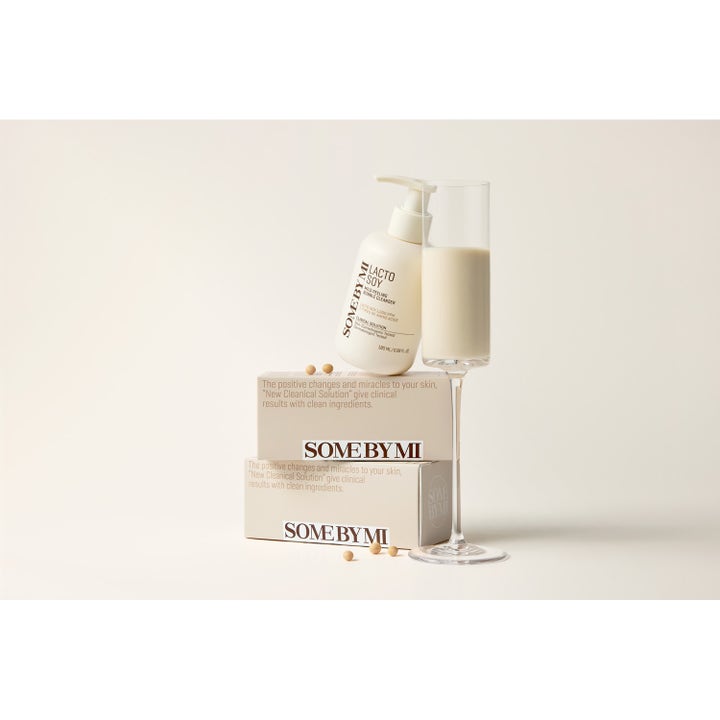 Some By Mi Lactosoy Mild Bubble Peeling Cleanser 180 ml renseskum hvit flaske på esker ved et glass med kremet soyavæske