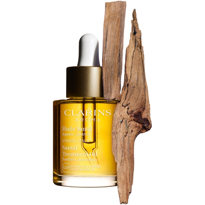 Clarins Santal Face Treatment Oil 30 ml beroligende ansiktsolje i glassflaske med gullkork og biter av sandeltre