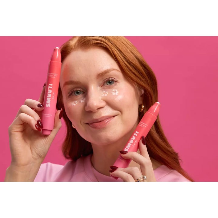 Smuuti Skin Strawberry Boost Eye Cream 15 ml øyekrem med vitamin C holdes av kvinne med kremprikker under øynene.