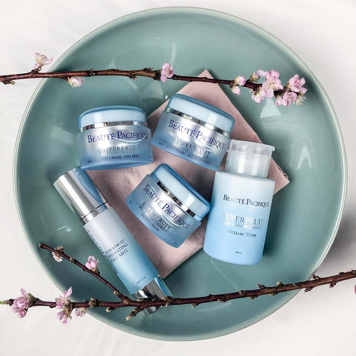 Beauté Pacifique Superfruit Enforcement Day Cream 50 ml hudpleie i lyseblå krukker på et fat med rosa blomster