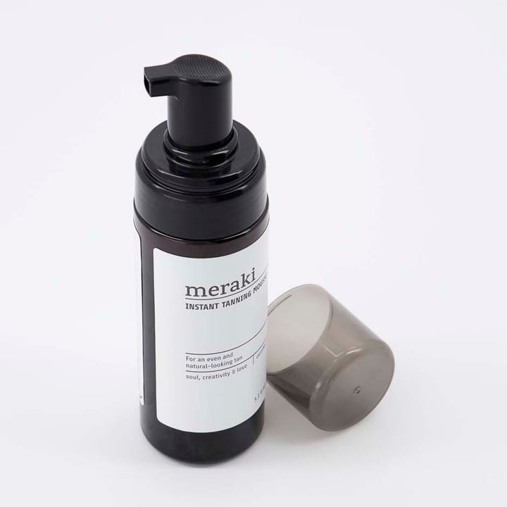 Meraki Instant Tanning Mousse 150 ml gir naturlig glød i mørk pumpeflaske med hvit etikett og avtatt lokk.