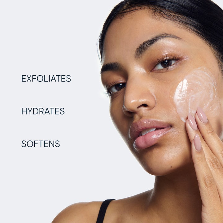 Elemis Pro-Collagen Glow Boost Exfoliator 100 ml ansiktsskrubb som eksfolierer og hydrerer påført på modellens kinn.