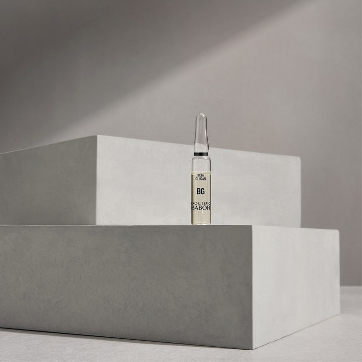 Babor DOC Instant Soothing Ampoule Serum 14 ml beroligende ansiktsserum i glassampulle med Beta Glucan på grå stein.