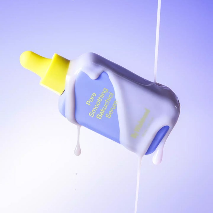 By Wishtrend Pore Smoothing Bakuchiol Serum 30 ml utjevnende serum i lilla flaske dekket av hvit kremet tekstur.