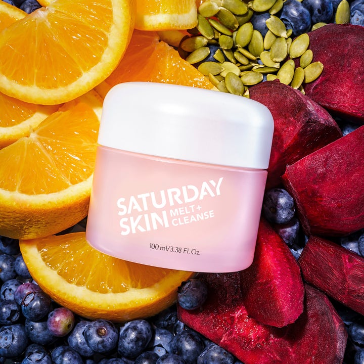 Saturday Skin Melt + Cleanse 100 ml rensende balm i krukke omgitt av appelsin, rødbeter og blåbær