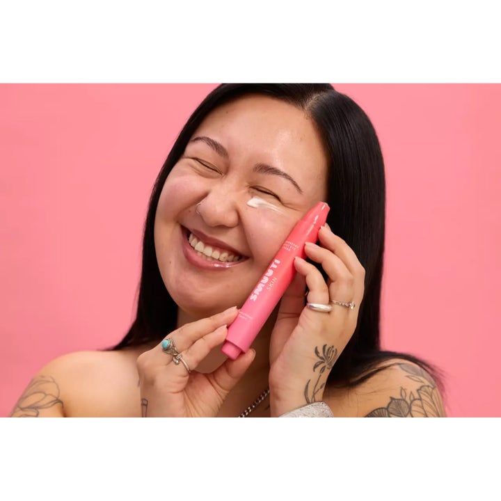 Smuuti Skin Strawberry Boost Eye Cream 15 ml fuktighetsgivende øyekrem holdt av kvinne med krem under øyet