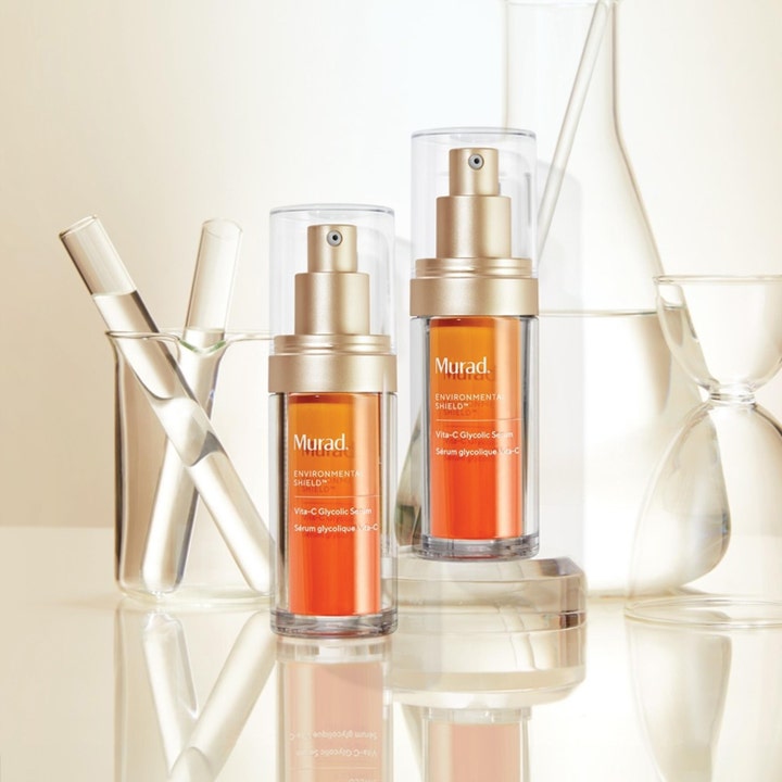 Murad Vita-C Glycolic Serum 30 ml glødgivende serum i to oransje flasker blant glasskolber og reagensrør