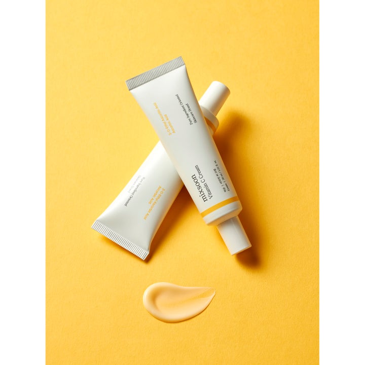 Mixsoon Vitamin C Cream 30 ml glødgivende ansiktskrem i hvite tuber med en ferskenfarget kremprøve på gul bakgrunn