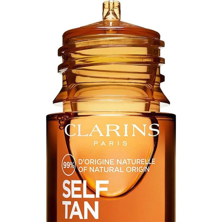 Clarins Golden Glow Booster selvbruning i ravfarget glassflaske som gir naturlig glød med 99 % naturlig opprinnelse.