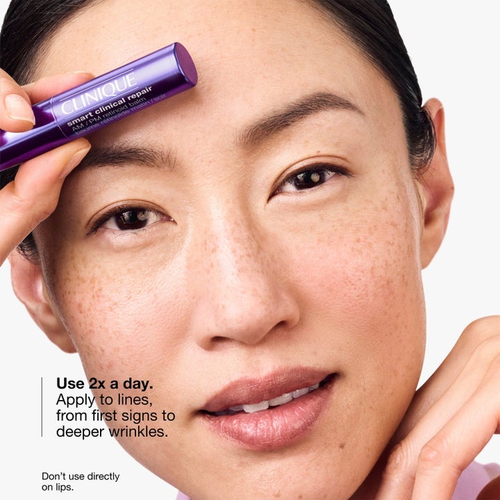 Clinique Smart Clinical Repair Retinoid Balm reduserer rynker med en lilla stift som holdes mot pannen.