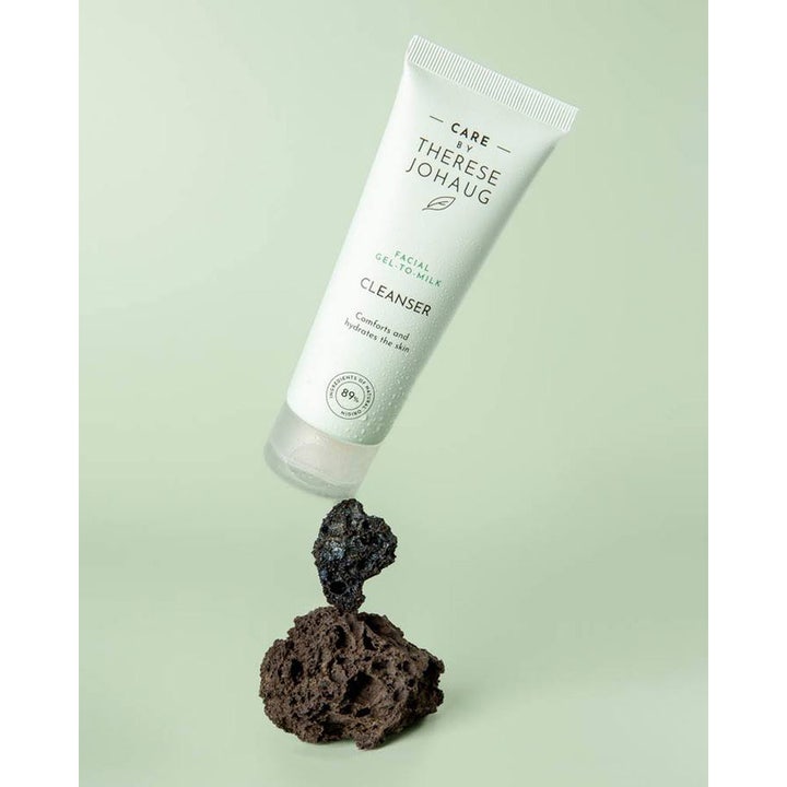 Care by Therese Johaug Cleanser Gel to Milk 75 ml fuktende ansiktsrens i hvit tube balansert på mørke lavasteiner.