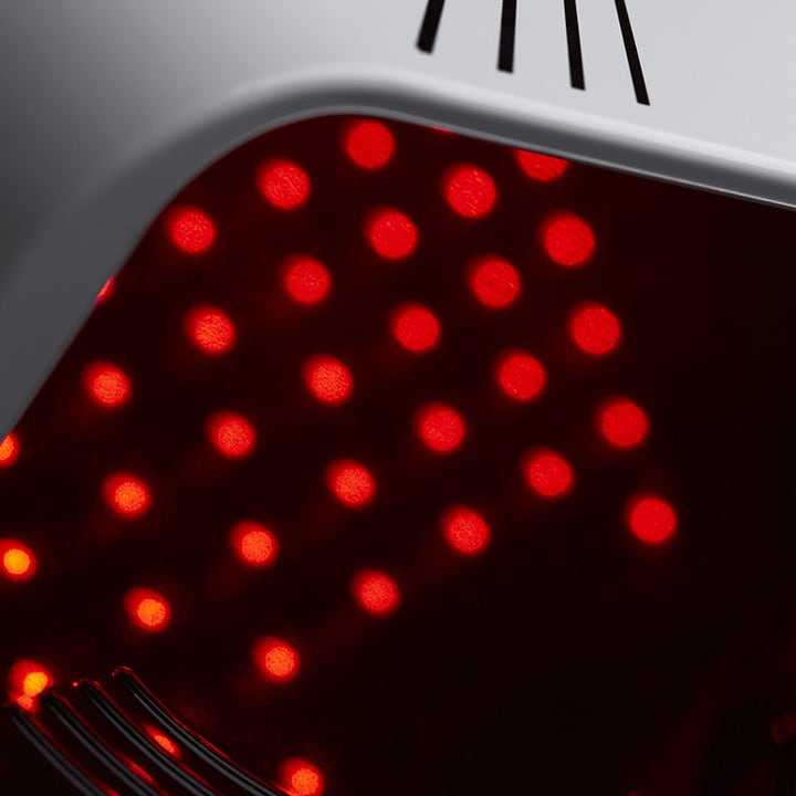 Currentbody Skin LED Hand Perfector beauty tech for hendene viser et nærbilde av de mange glødende røde LED-lysene
