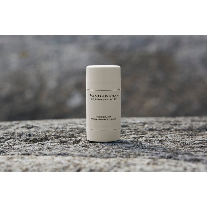 DKNY Cashmere Mist Deodorant Stick beskyttende anti-perspirant i beige hylse på en naturlig grå stein.