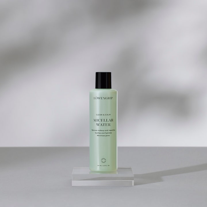 Löwengrip Clean & Calm Micellar Water 230 ml beroligende rens i lysegrønn flaske med sort kork på glassplattform