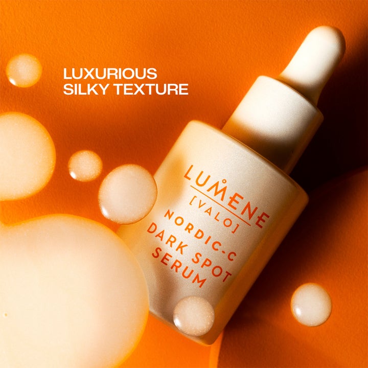 Lumene Dark Spot Serum 30 ml glødgivende ansiktsserum i glassflaske med dråper av luksuriøs silkeaktig tekstur.